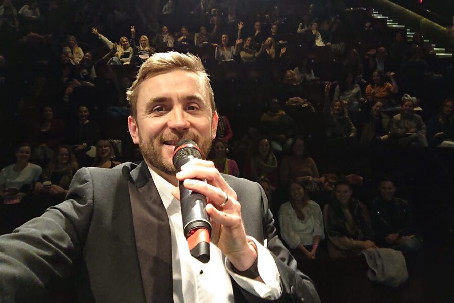 Kevin Durham on the mic with a full auditorium behind him