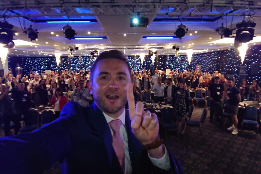 Kevin Durham in front of a packed conference hall, hundreds of delegates behind him