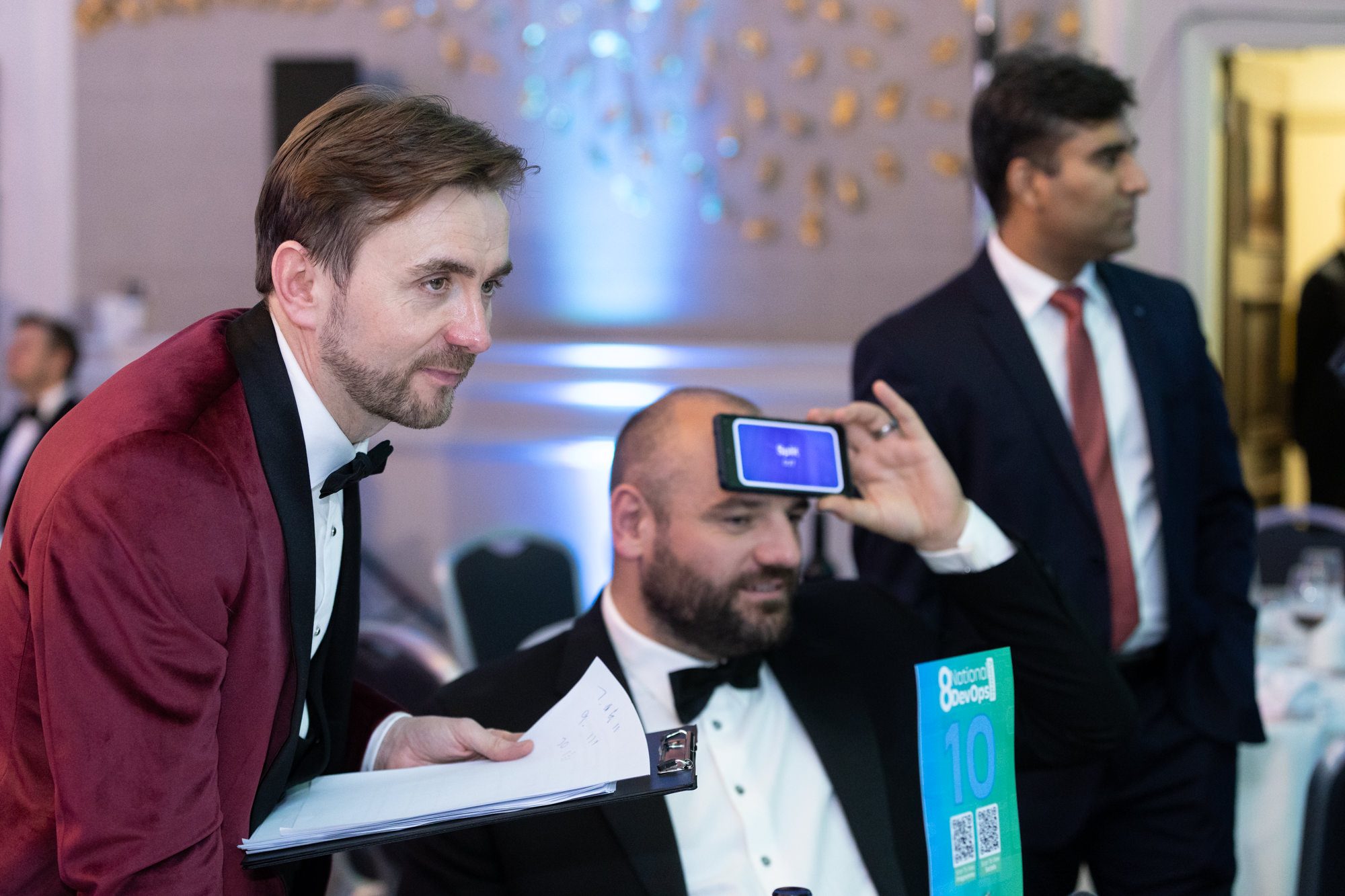 A delegate holding a phone to his forehead in a whole-room icebreaker