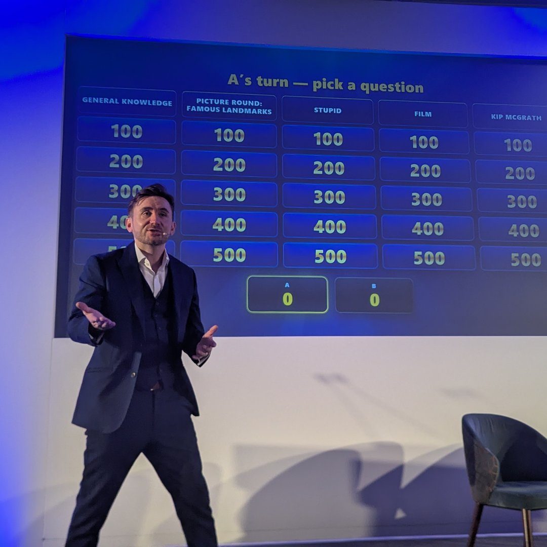 Kevin Durham hosting a conference, running a live quiz show game on the big screen