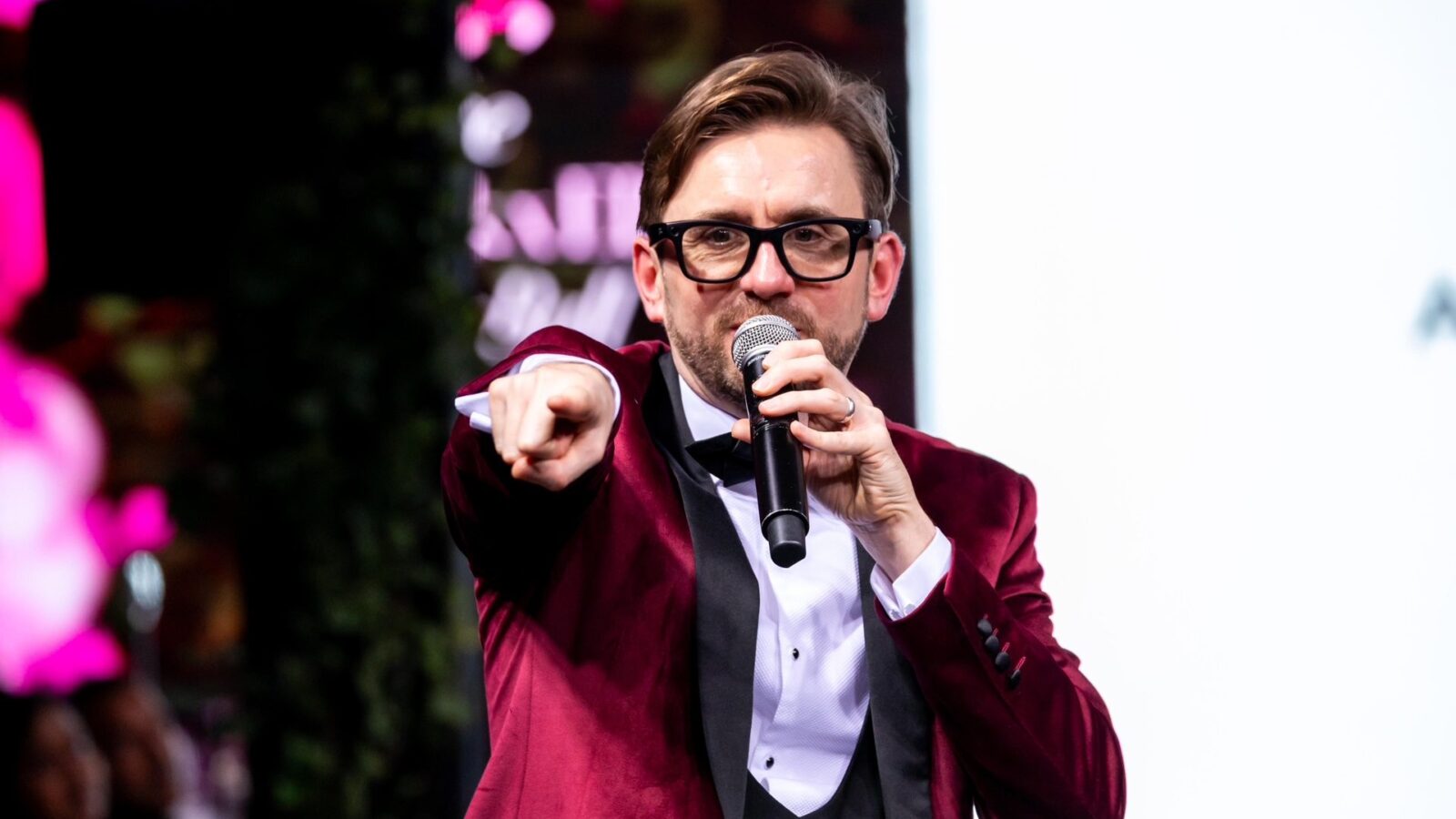 Kevin Durham hosting a game show round, pointing to the audience