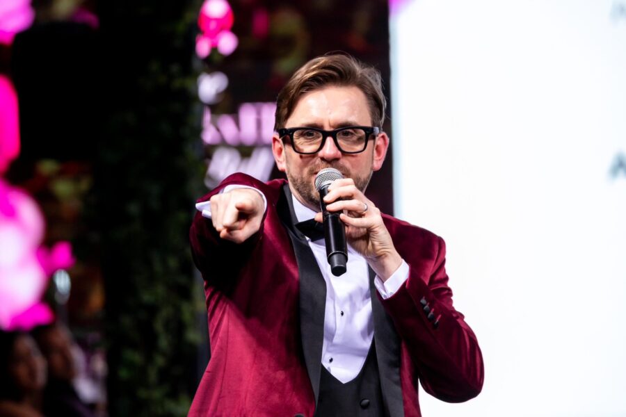 Kevin Durham hosting a game show round, pointing to the audience