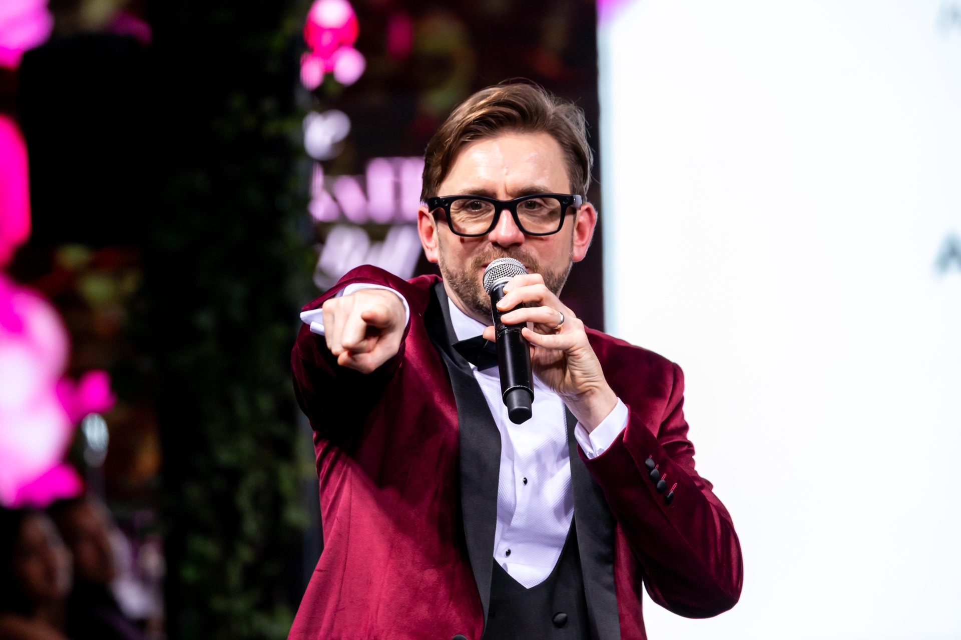 Kevin Durham hosting a game show round, pointing to the audience